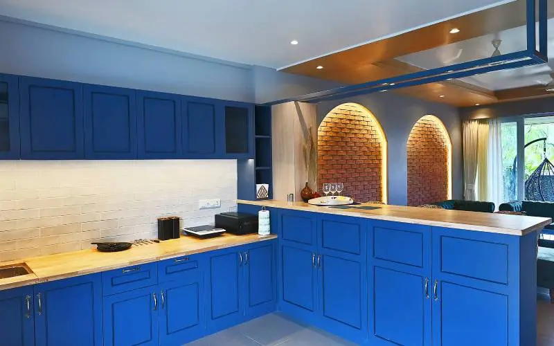 Veci villa lonavala Kitchen in blue with self cooking induction and tandoor with bar and bar chairs